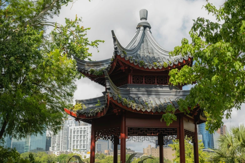 a pagoda structure in the middle of some trees and green grass