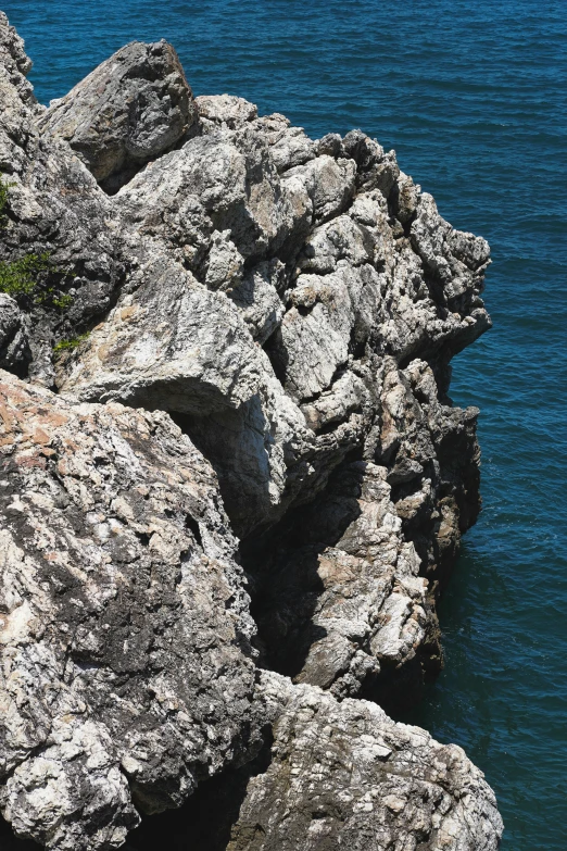 a bunch of rocks on the side of a body of water