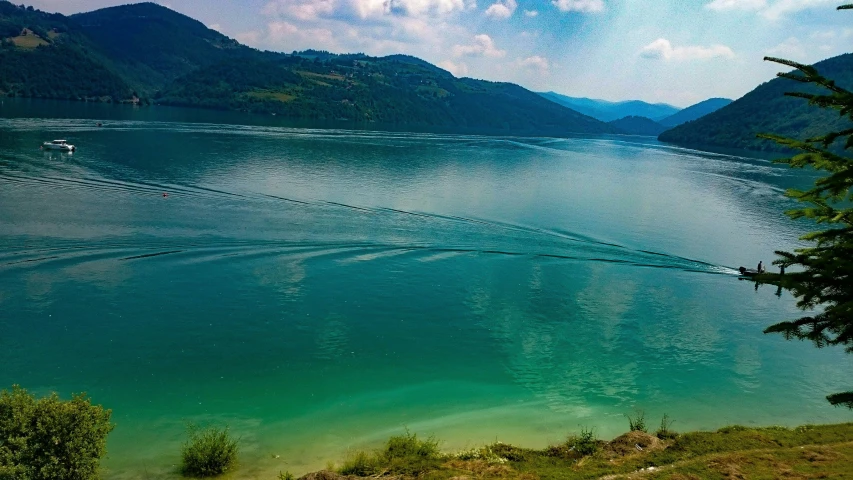 an open view from the top of a hill looking down on a lake