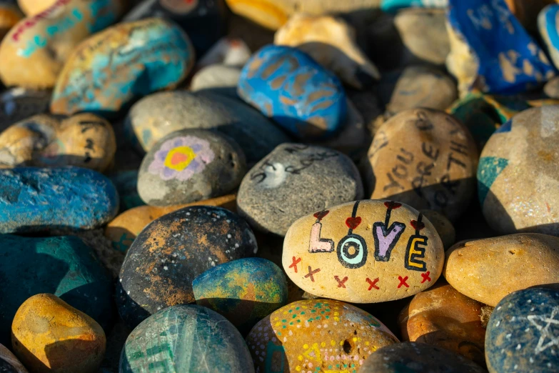 several colored rocks with writing on them are displayed together