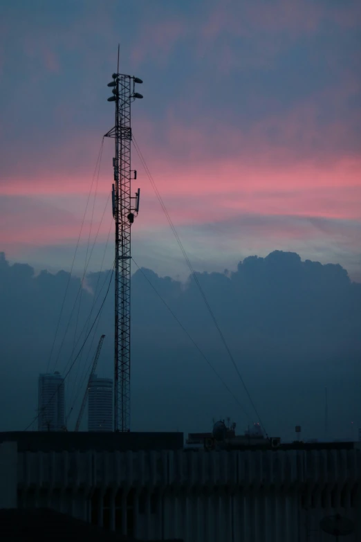 a very tall tower sitting under a pink cloudy sky