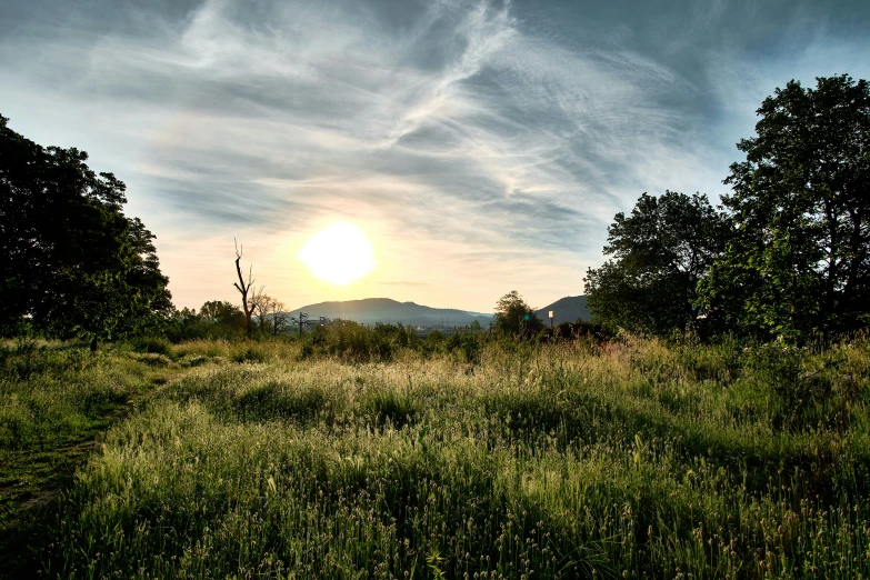 an image of a sun setting over some hills