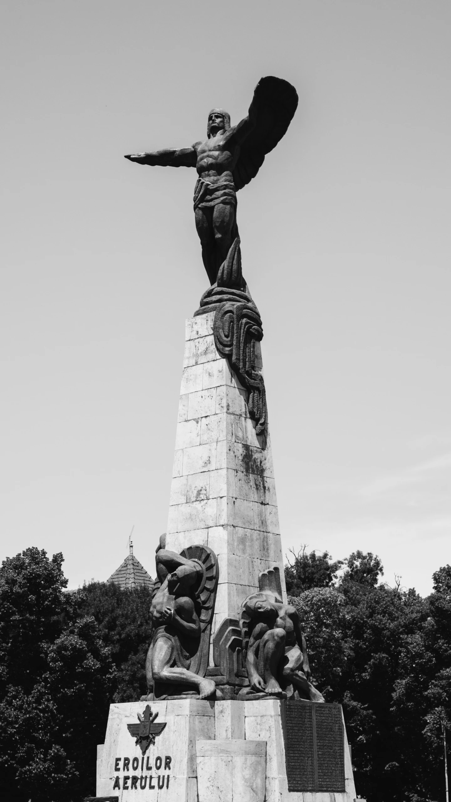 black and white po of a statue of a lady on the edge of the building