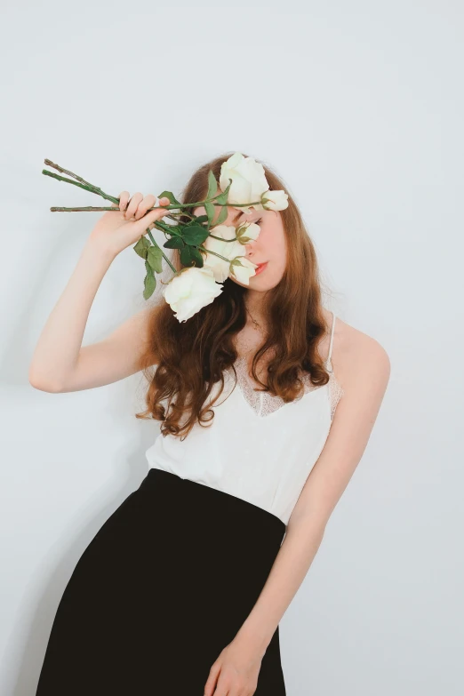 a woman holding flowers with her hands while posing