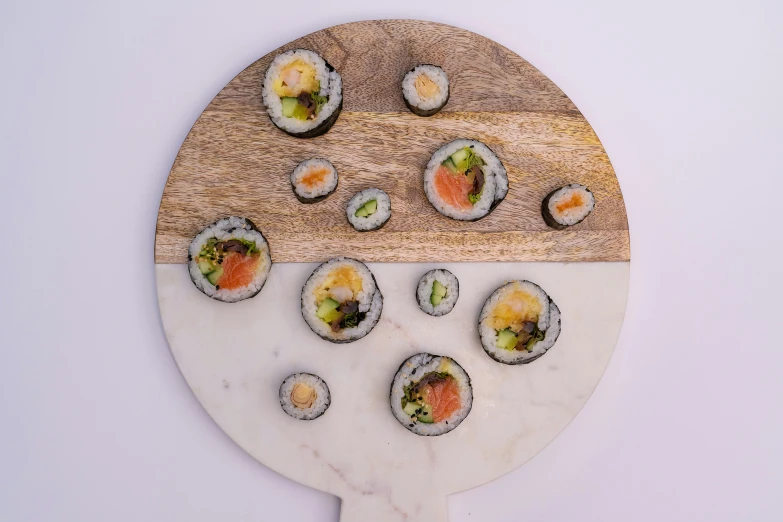 several different sushi in a tray on a white surface