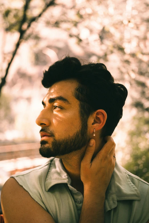 man wearing ear rings looking into the sky