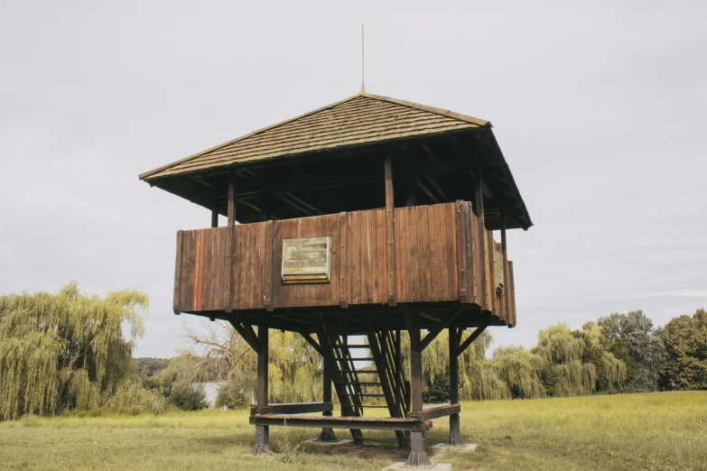 a tall wooden tower sitting in the middle of a field