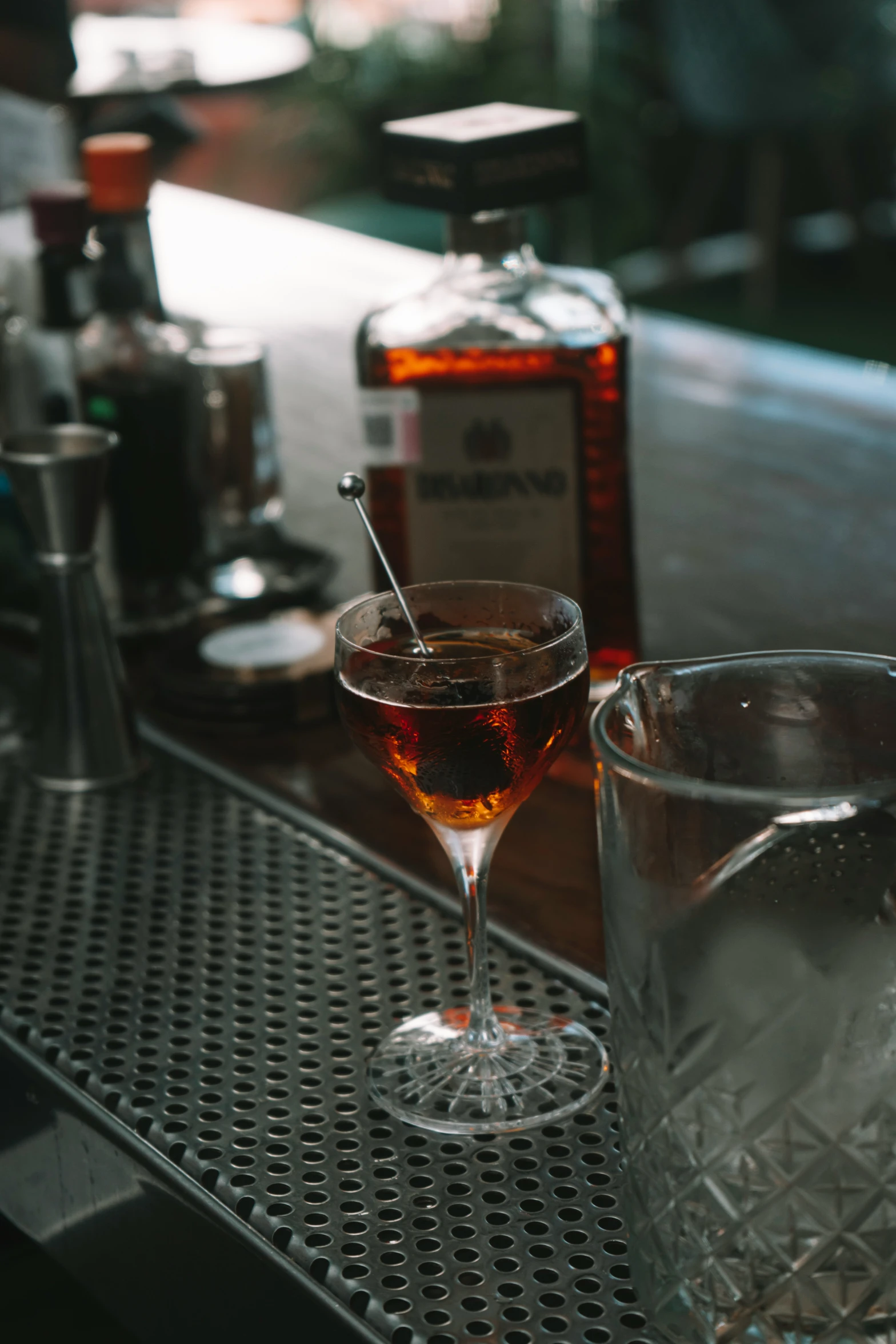 the drink is sitting on the bar with a spoon in it