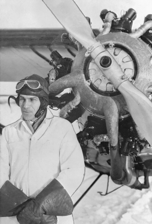 a black and white po shows an old fashioned airplane with two pilots