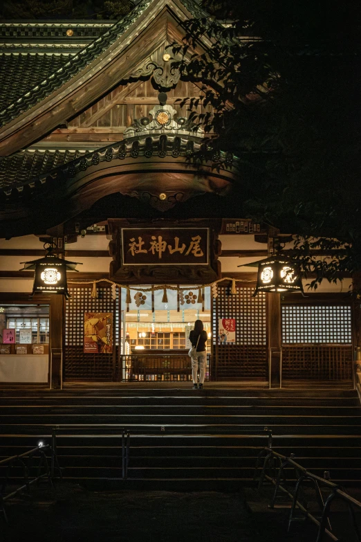 a couple standing in front of a building at night