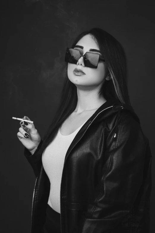 black and white po of woman with sunglasses smoking a cigarette