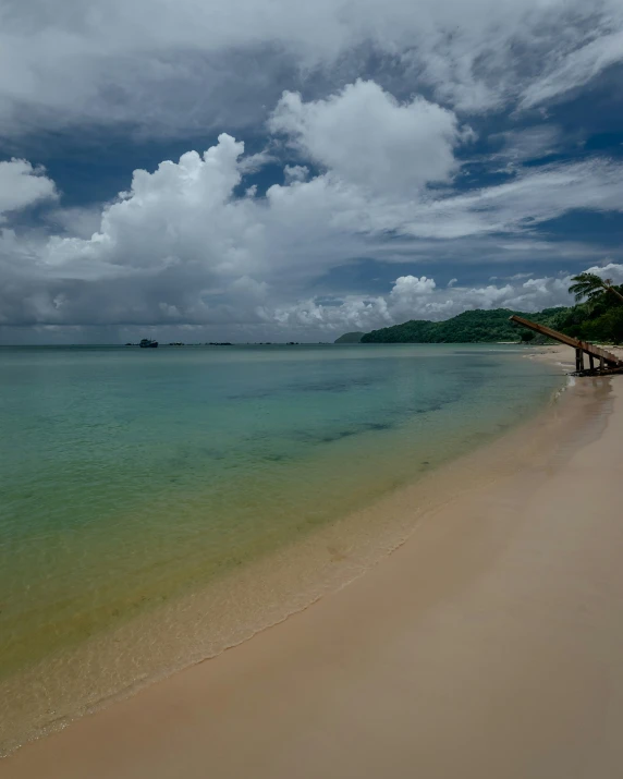 green and blue water with white clouds in the background