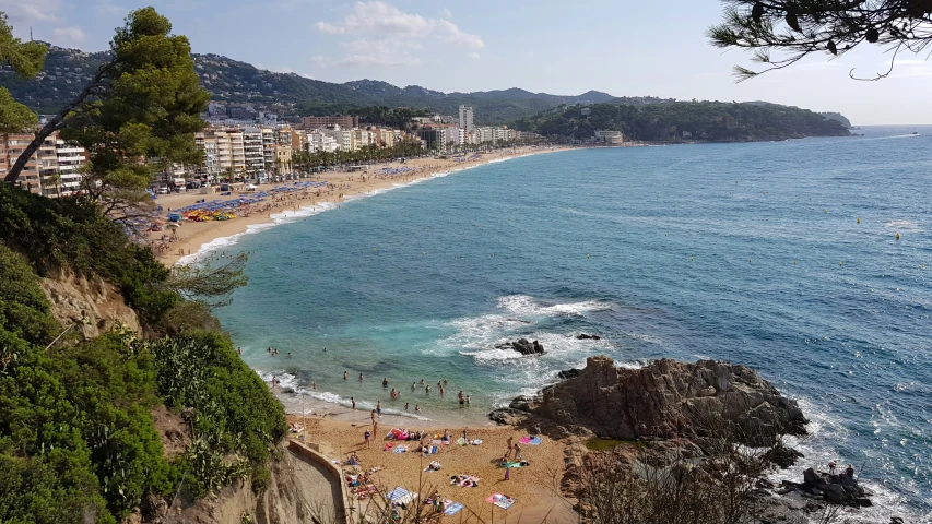 an ocean beach with people sitting in it near the shore