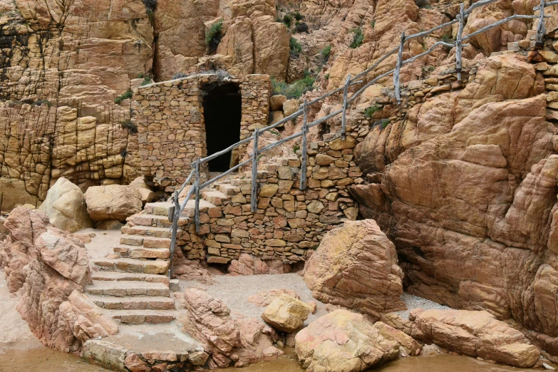 steps that lead down to a cave, surrounded by rocky formations