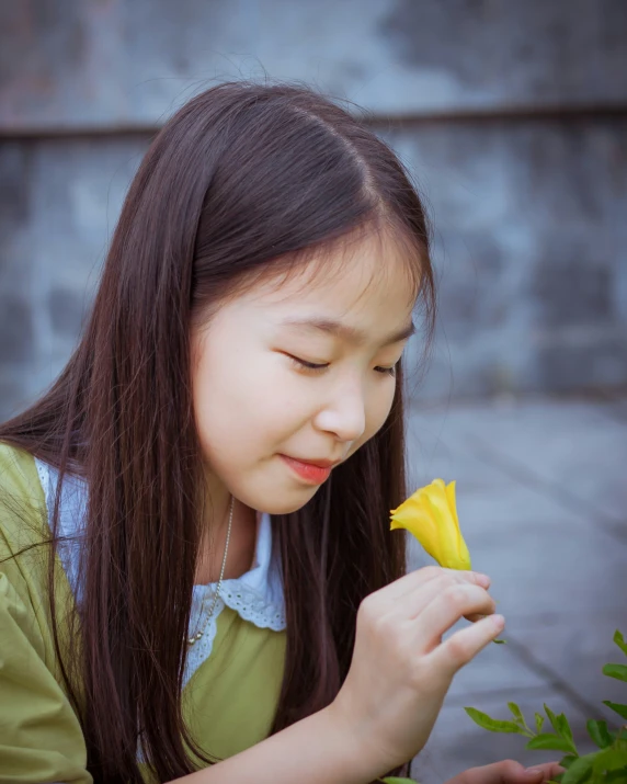 a child holding onto a flower in her hand