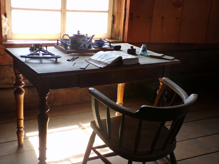 the table and chair is covered with lots of books