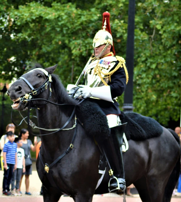 a man in a uniform riding a horse down a street