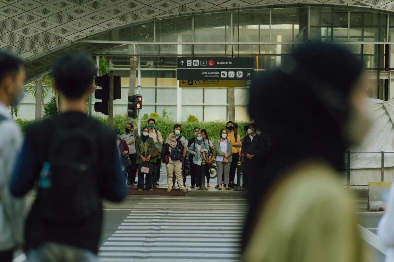 a group of people standing at a stop light