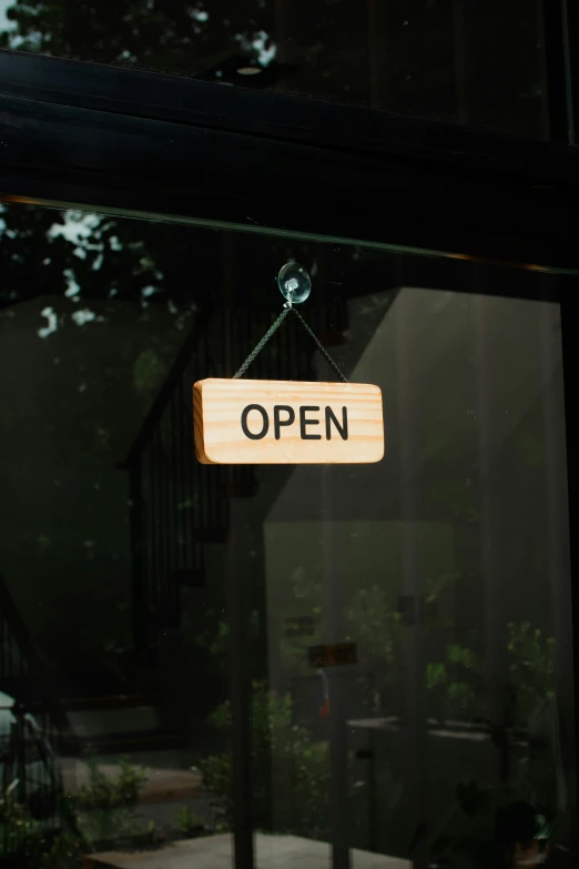 a window with a wooden sign hanging from it