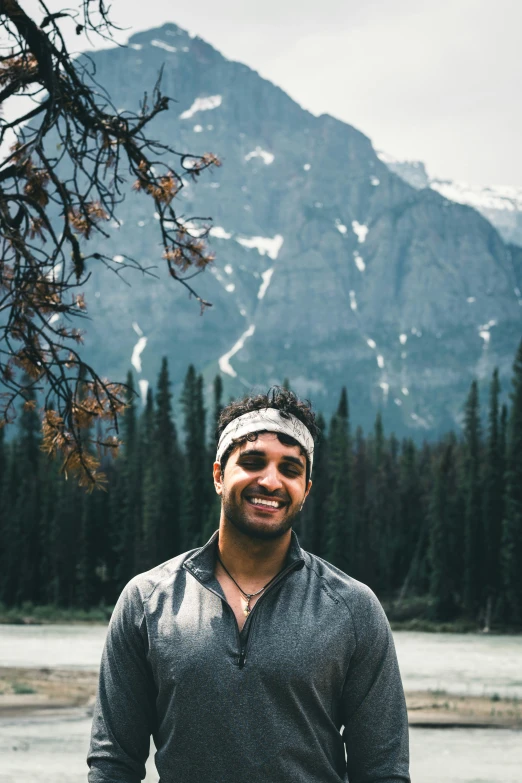 a man with a blindfold stands in front of a mountain