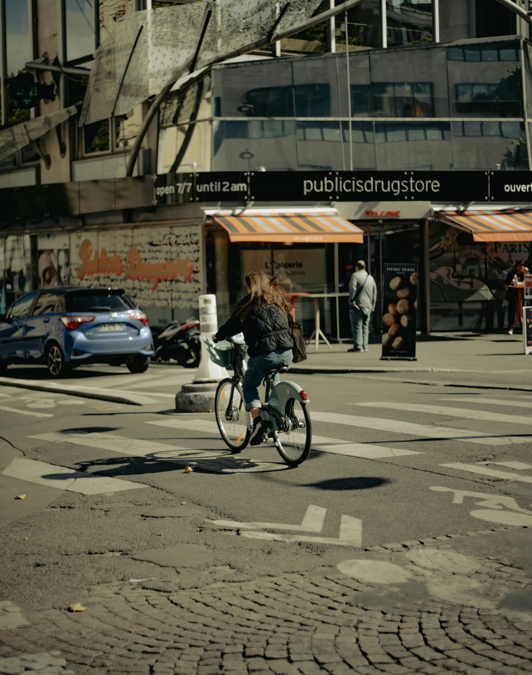 a bicyclist passing through a cross walk area on a busy street