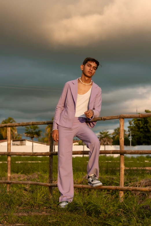 a man is posing by the fence for a picture