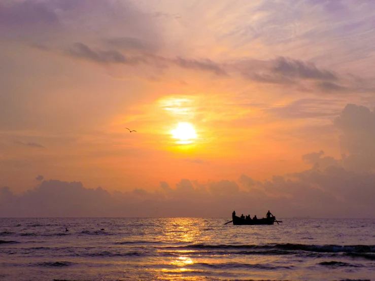 people are out in the water at sunset