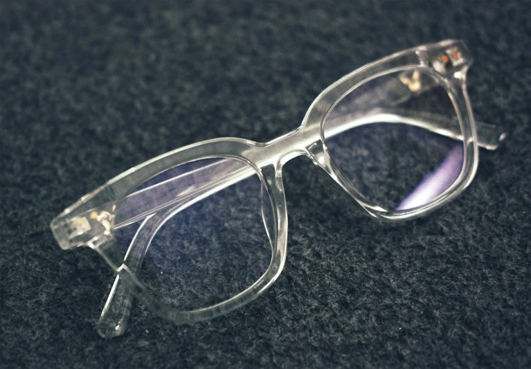 an old pair of clear glasses on a black surface