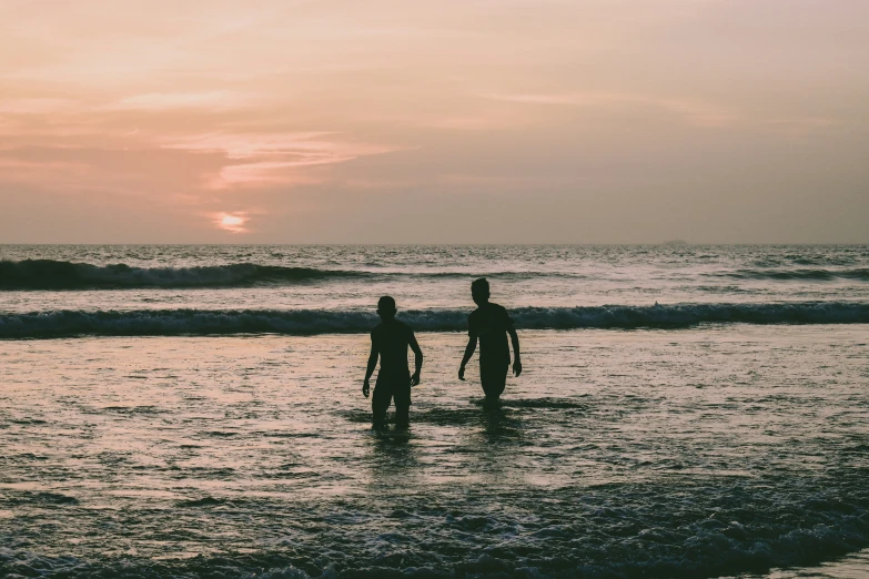 two people walking out of the water