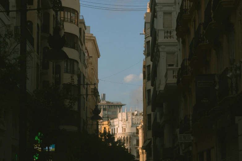 buildings surrounding a narrow road at twilight