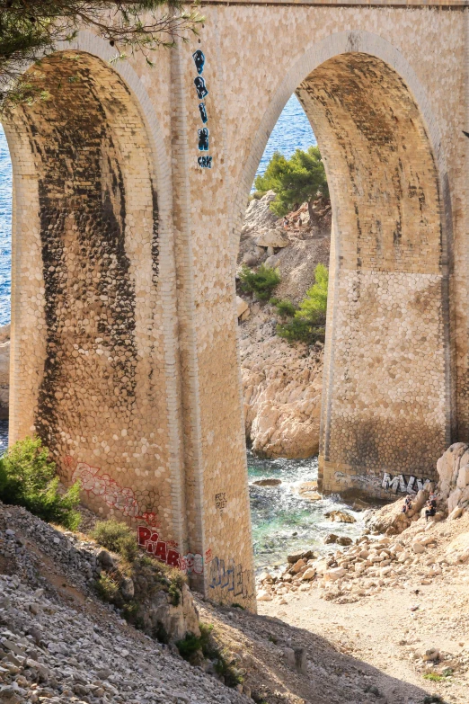 a stone bridge with three arches over a body of water