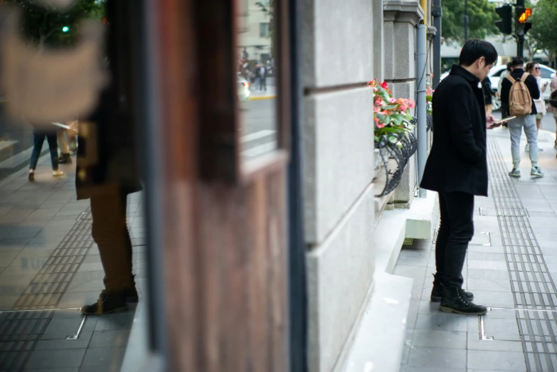 two people standing on the street in front of some shops