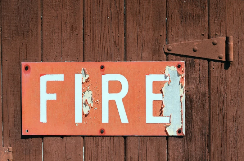 a red fire sign hanging from a wooden door