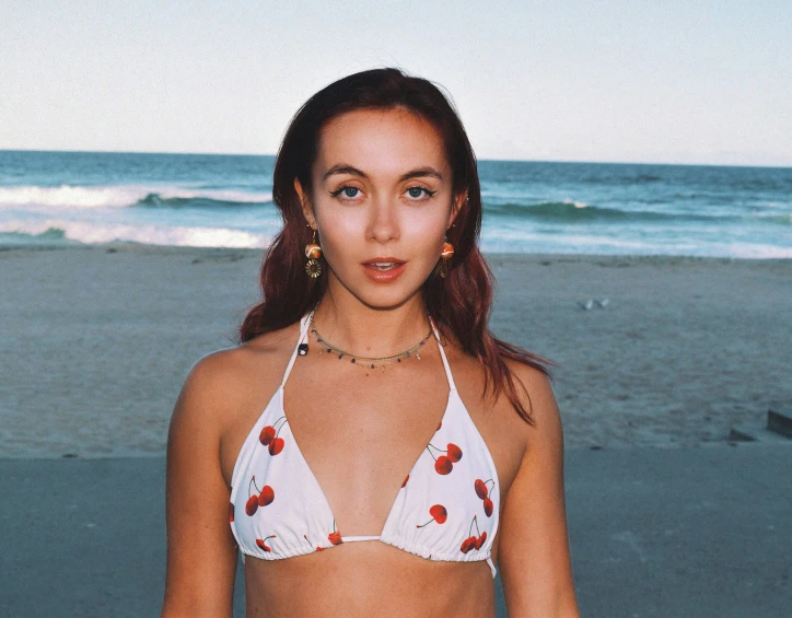 the woman is standing on the beach in her bikini