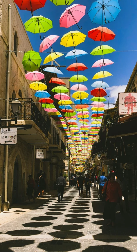 colorful umbrellas are in the air and on the street