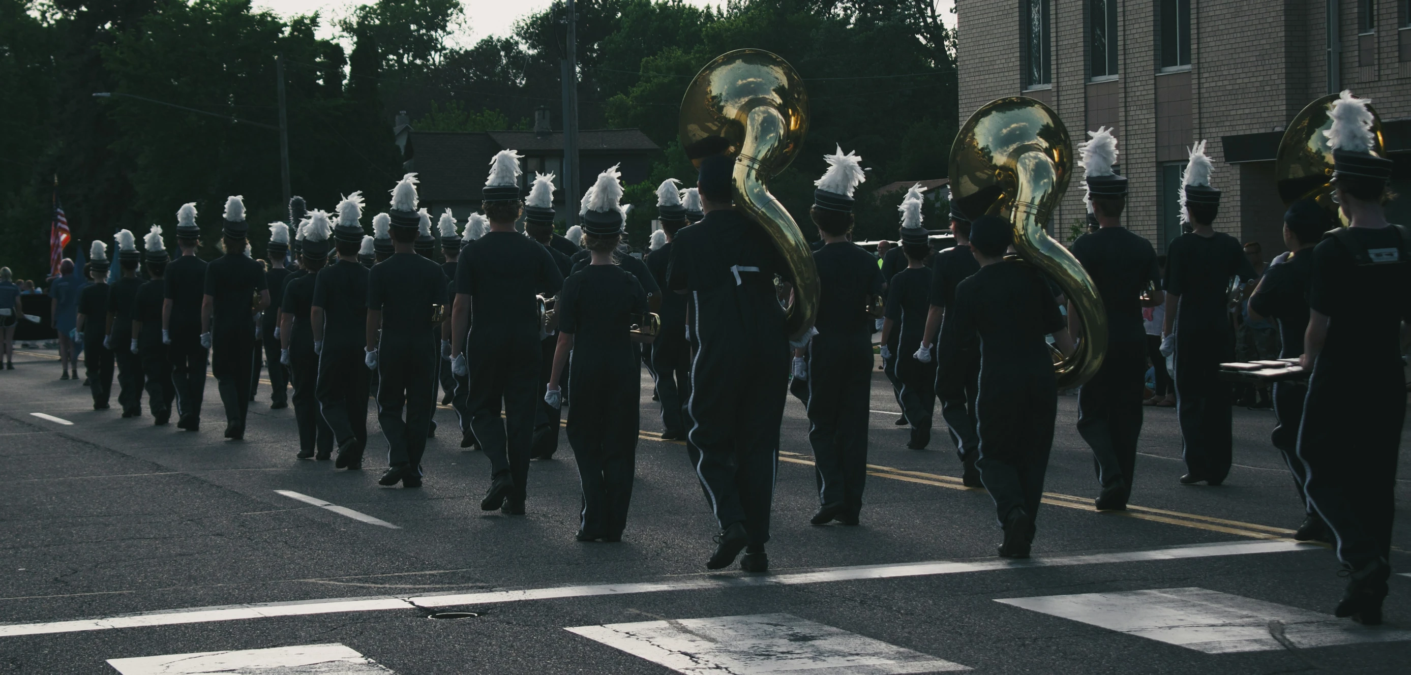 a marching band in a parade with white masks on their faces