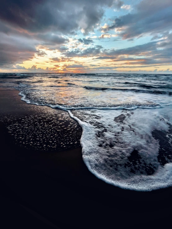 the ocean has washed rocks on it and foamy water