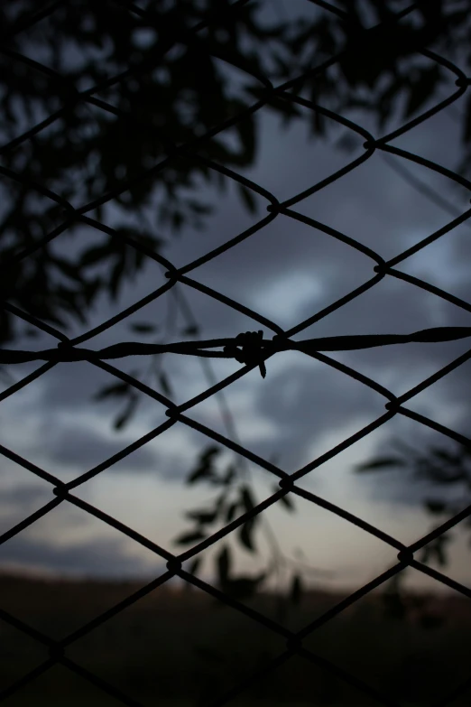 a close - up view of the sky through a chain link fence