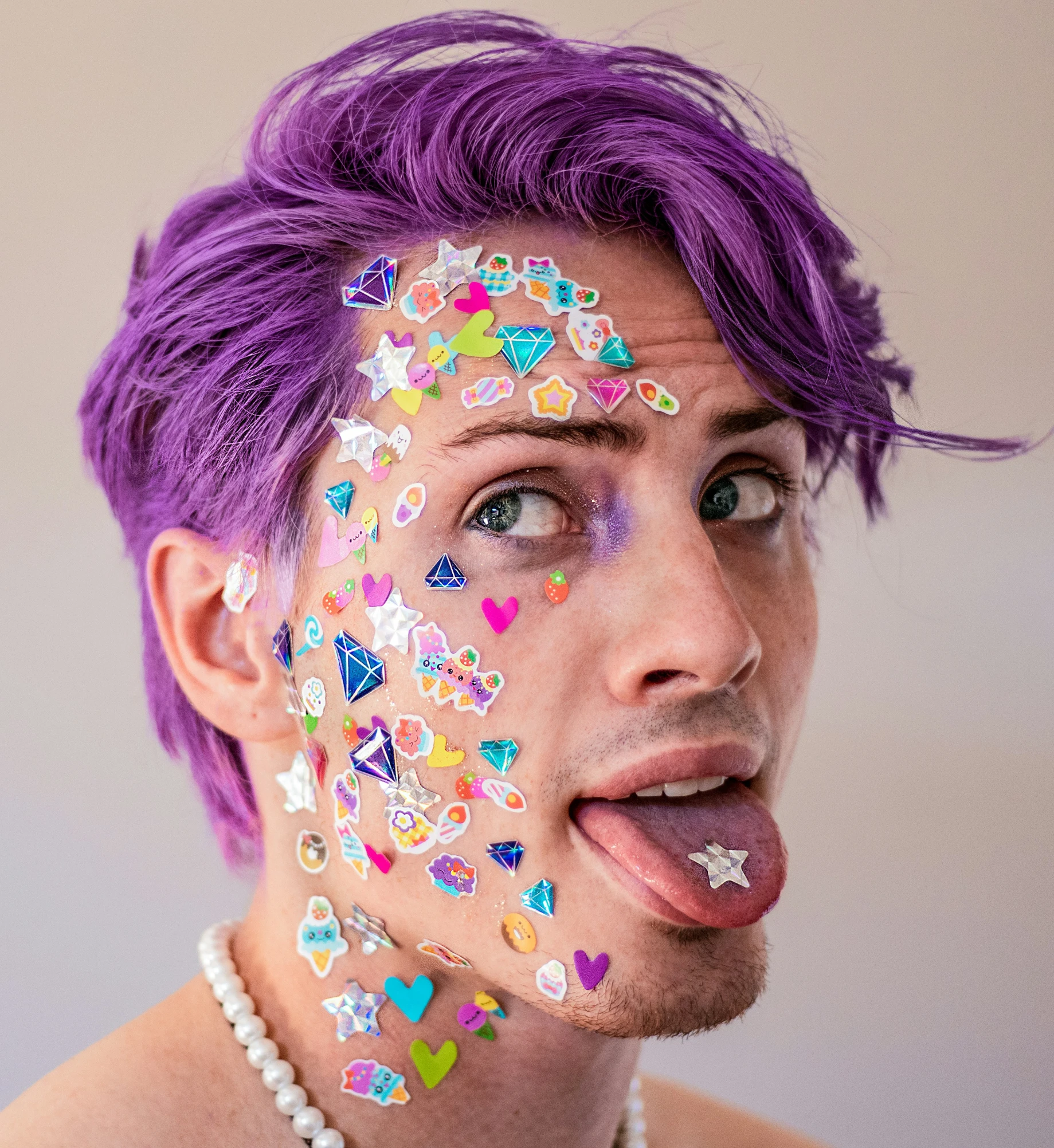 a man with purple hair and a necklace on his face