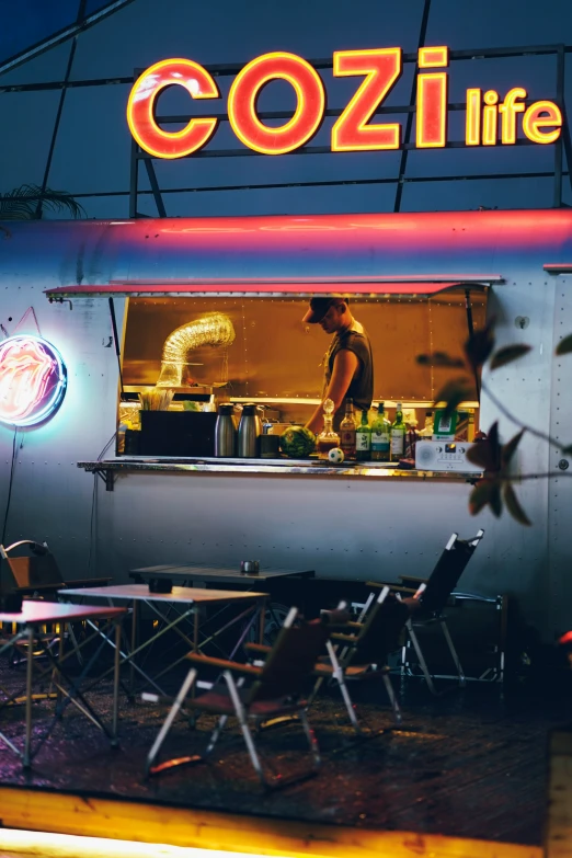 the man is standing in the window of his food cart