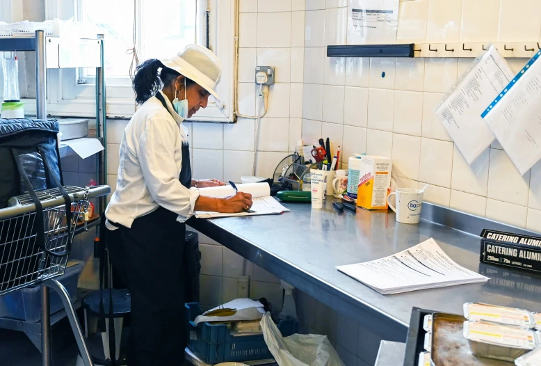 woman preparing food in kitchen setting with menu