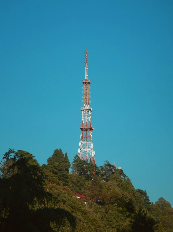 an antenna tower on top of a green mountain