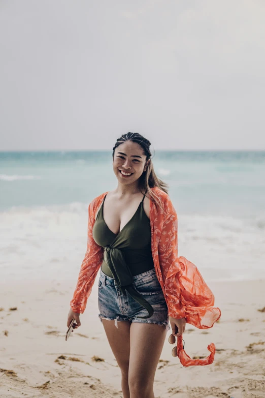 a woman is smiling while standing on the beach