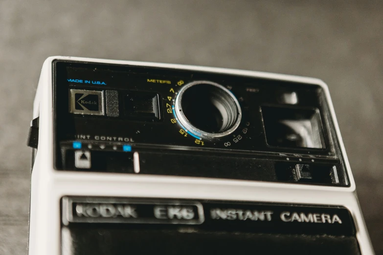 an old digital camera sitting on top of a white box