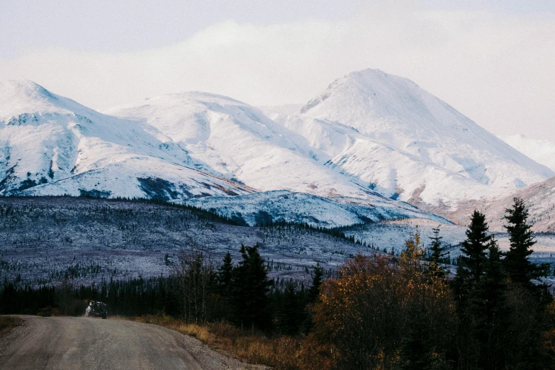 the road is in front of some snow covered mountains