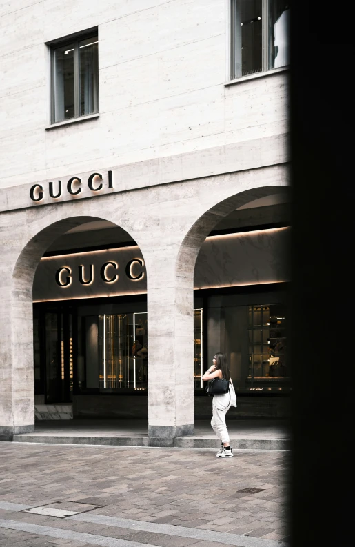 woman in white dress taking pos of storefronts