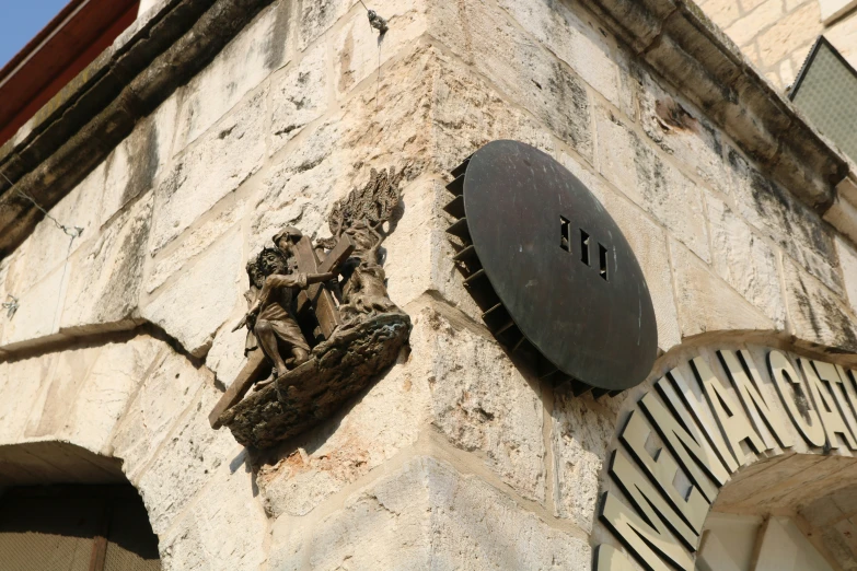 two sculptures of lizards are displayed on the outside of a stone building