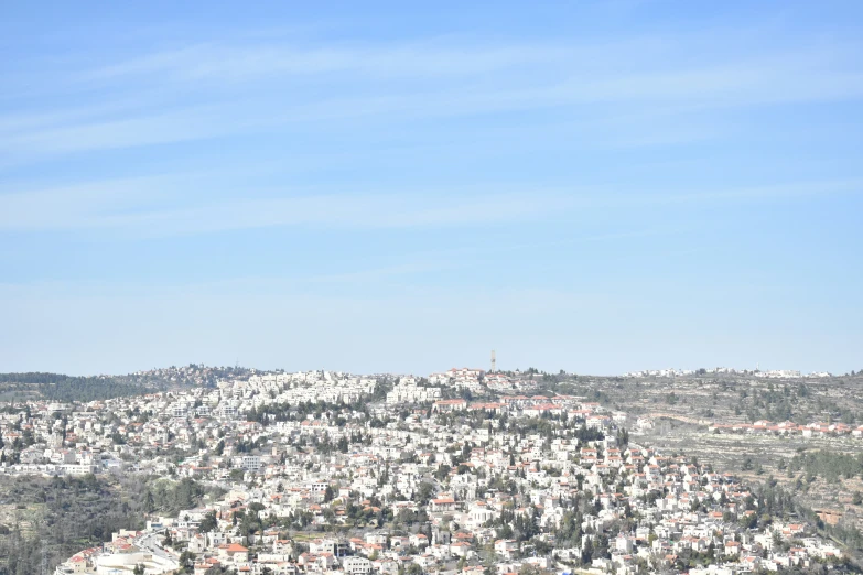a city with a few buildings on the hill and some trees on the hillside