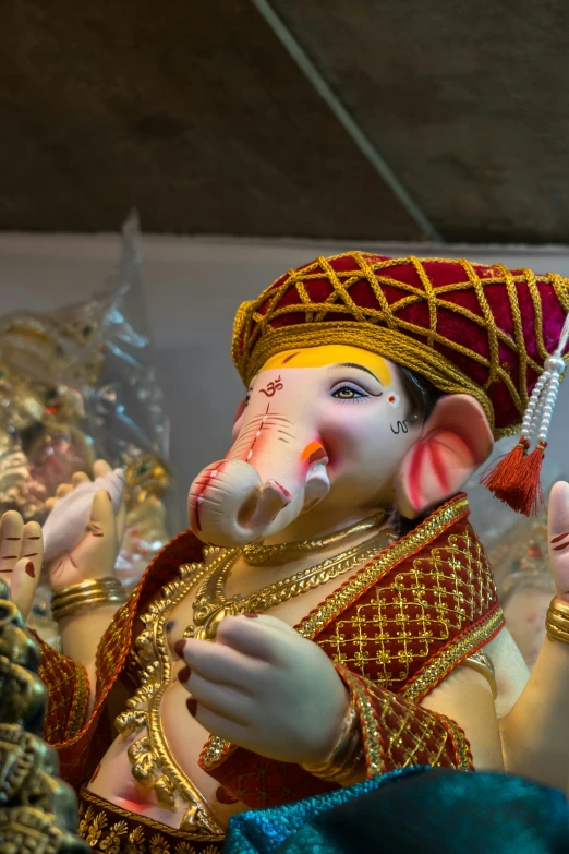 ganesh idol with hands extended and hat on