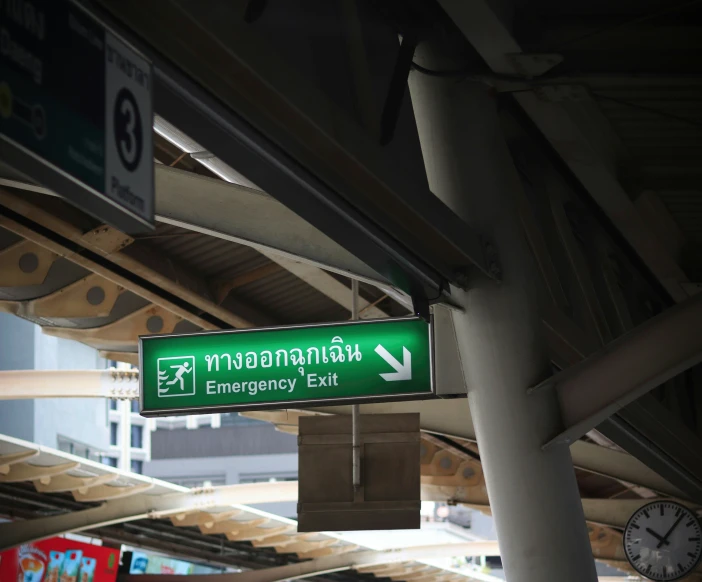 a green sign points to the exit for myanmar central exit